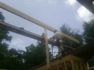 Carpenter setting a ridge beam over a new addition frame — Ice Dam Removal by Roofing Brothers in Edgar